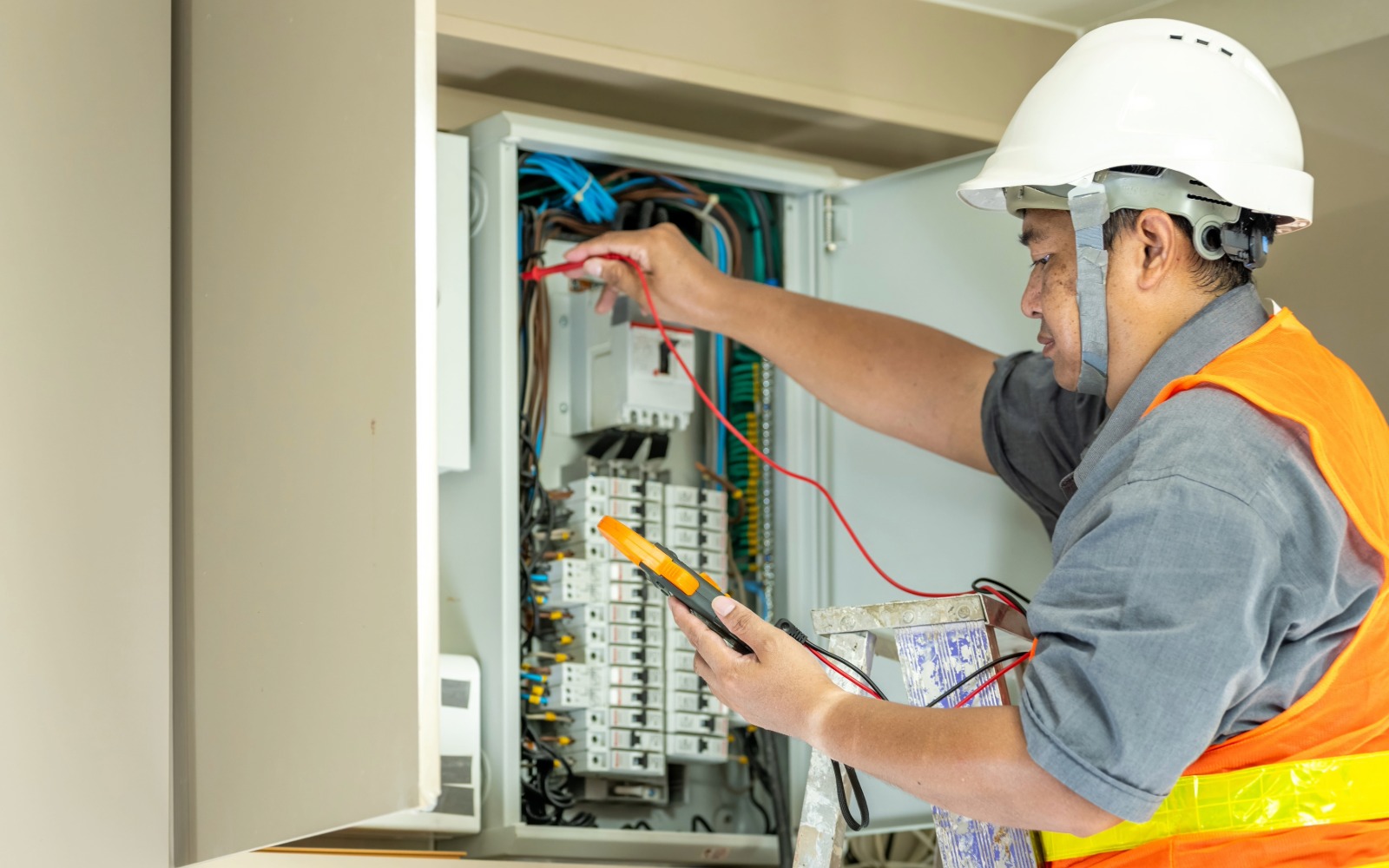 Electrician troubleshooting a commercial electrical panel